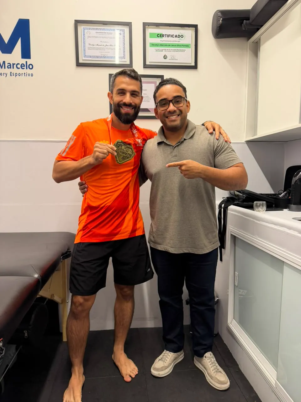 Paciente medalhista comemorando com o Dr. Develyn no consultório
