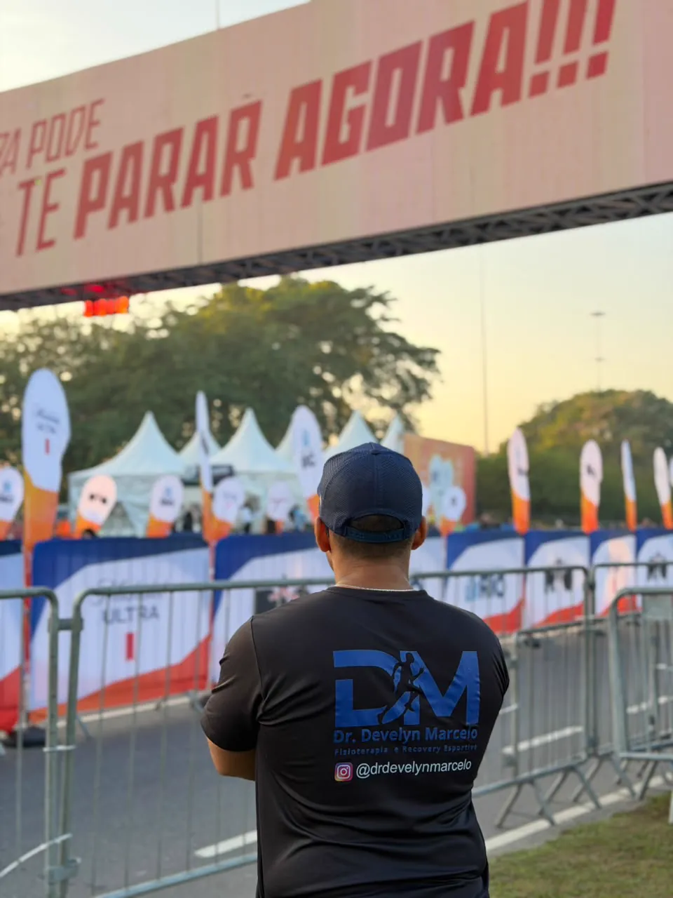 Dr. Develyn Marcelo com a camisa DM observando a linha de chegada de uma corrida